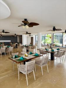 a dining room with tables and chairs and windows at Jardin d'orient in Dakar