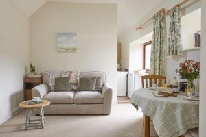 a living room with a couch and a table at Willows in Calbourne