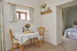 a dining room with a table and chairs and a bed at Willows in Calbourne