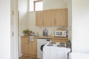 a kitchen with a washing machine and a microwave at Willows in Calbourne