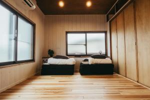 two beds in a room with two windows at 民泊やまねこ in Yachi
