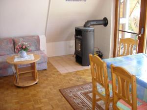 a living room with a wood stove and a table at PRHS08001-FeHaus-Diekkroon in Presen +2 photos
