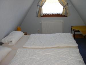 a bedroom with a white bed with a window at PRHS08001-FeHaus-Diekkroon in Presen