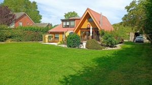 a house with a red roof on a green lawn at PRHS08001-FeHaus-Diekkroon in Presen