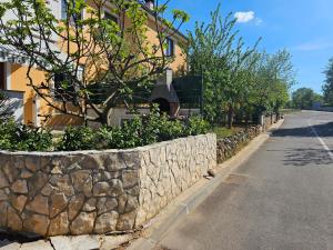 a stone retaining wall next to a street at Apartment Luna in Malinska