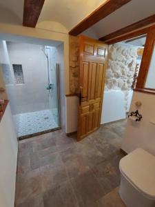 a bathroom with a shower and a toilet and a door at The Retreat in Las Encebras +16 photos