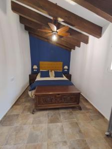 a bedroom with a bed and a ceiling fan at The Retreat in Las Encebras