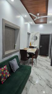 a living room with a green couch and a table at Deoghar BnB in Deoghar