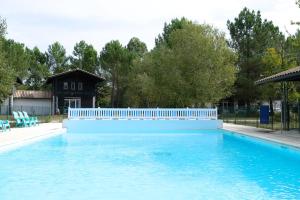 a swimming pool with a white fence around it at La Cachette du Lac-Douce parenthèse en famille près du lac & piscine in Lacanau
