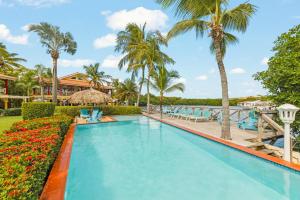 a swimming pool with palm trees and a resort at Marina Apartment A2, luxury waterfront apartment Spanish Water, Jan Thiel, Curaçao in Jan Thiel