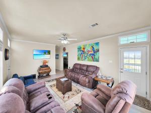 a living room with leather couches and a table at It's a Shellabration home in Crystal Beach