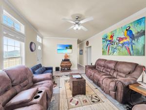a living room with couches and a ceiling fan at It's a Shellabration home in Crystal Beach +83 photos