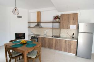 a kitchen with a wooden table and a refrigerator at Agnanti in Agia Fotini
