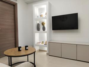 a living room with a tv and a table at Calm Horizon Residence in Chios