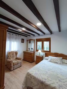 a bedroom with a large bed and a chair at Casa Vacacional Villa Martina in Valmeo