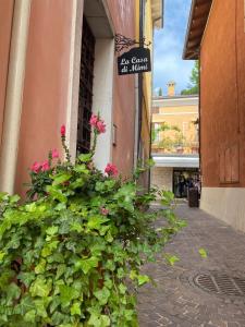 a sign on the side of a building with flowers at La Casa Di Mimi in Bardolino