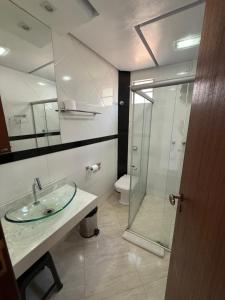 a bathroom with a sink and a glass shower at Hotel Pousada Getsemani in Mariana +63 photos