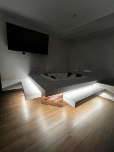 a room with a flat screen tv and a wooden floor at Hotel Atenas in Barranco +12 photos