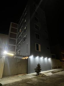 a building with lights on the side of it at night at Hotel Atenas in Barranco