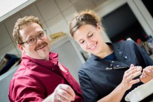 een man en een vrouw die eten klaarmaken in een keuken bij Gasthof zum Hammer in Göstling an der Ybbs