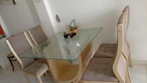 a glass table with two chairs and a plant on it at HOSTAL CARACOLI - HUECO in Valledupar +25 photos