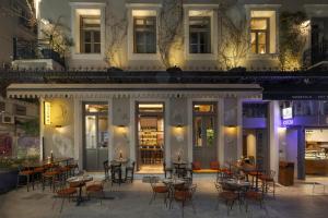 a restaurant with tables and chairs in front of a building at Airy Athens Suites in Athens