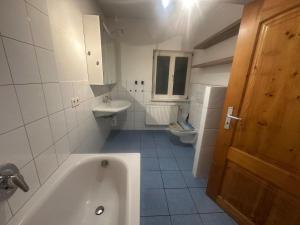 a bathroom with a tub and a sink and a toilet at Monteure Maisonette in Eggingen