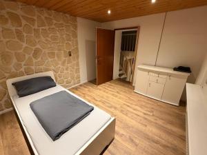 a small room with a bed and a stone wall at Monteure Maisonette in Eggingen