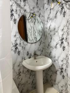 a bathroom with a white sink and a mirror at Max Heron in Ikeja