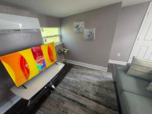 a living room with a tv and a couch at Backyard Cottage in Naples
