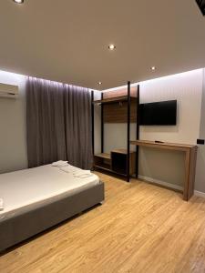 a bedroom with a bed and a flat screen tv at Mario Rooms in Vlorë