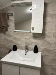 a white sink in a bathroom with a mirror at Къща за гости Гергана in Troyan +33 photos