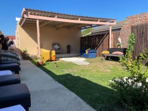 a backyard with a wooden pergola and grass at Zambata Self Catering in Gqeberha