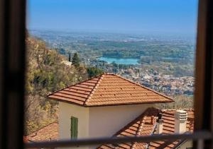 a building with a tile roof with a view of a city at Locanda Milano 1873 in Brunate