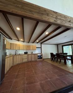 a large kitchen with wooden ceilings and a table at Casa Mayay in Ranco
