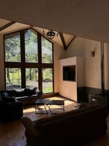 a living room with couches and a large window at Casa Mayay in Ranco