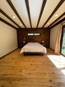 a bedroom with a bed and a wooden floor at Casa Mayay in Ranco