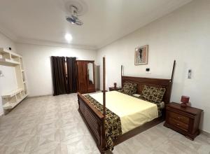 a bedroom with a large bed with a wooden frame at Résidence du Golf in Bamako
