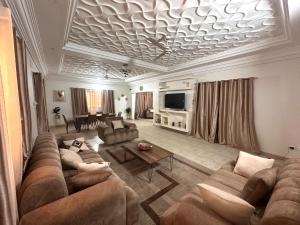 a large living room with a couch and a tv at Résidence du Golf in Bamako