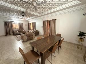 a living room with a wooden table and chairs at Résidence du Golf in Bamako +4 photos