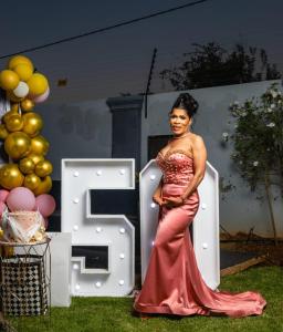 a woman in a dress standing in front of a sign at Pula Nala Lodge in Rustenburg +44 photos