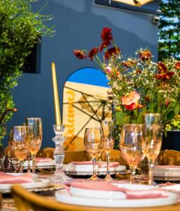 a table with wine glasses and flowers on it at Pula Nala Lodge in Rustenburg