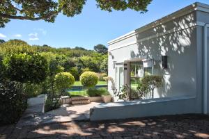 ein weißes Haus mit Terrasse und Garten in der Unterkunft Francolin Studio in Kapstadt