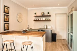 eine Küche mit einer Theke und zwei Hockern in der Unterkunft Francolin Studio in Kapstadt