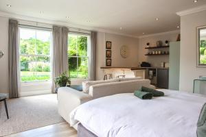 ein Schlafzimmer mit einem großen weißen Bett und einer Couch in der Unterkunft Francolin Studio in Kapstadt + 25 Fotos