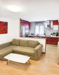 a living room with a couch and a kitchen at Apartamento Vitoria in Vitoria-Gasteiz