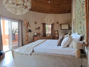 a bedroom with a large bed and a large window at Maison Talouma in Saly Portudal +36 photos