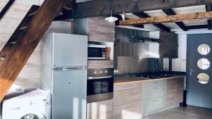 a kitchen with a refrigerator and a stove top oven at Le Cercle des Neiges Étoilé in Métabief