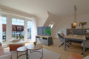 a living room with a tv and a dining room at PM09 KüstenReich in Wremen
