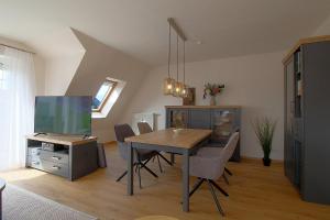 a dining room with a table with chairs and a tv at PM09 KüstenReich in Wremen
